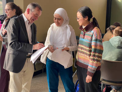 Professor Bridson discussing mathematics with students after the lecture